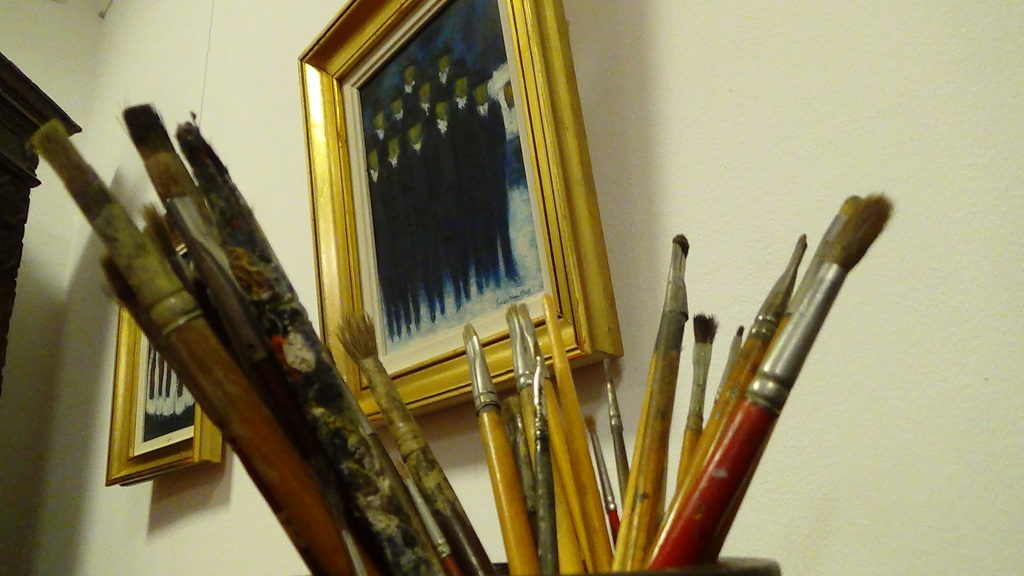 Györkös ecsetjei háttérben az egyik festményével | Fotó: a szerző felvétele